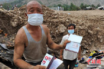 舟曲泥石流:男子挖出兒子照片失聲痛哭